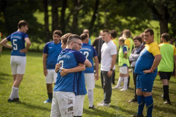 Teams Zwei Personen umarmen sich auf dem Fußballfeld