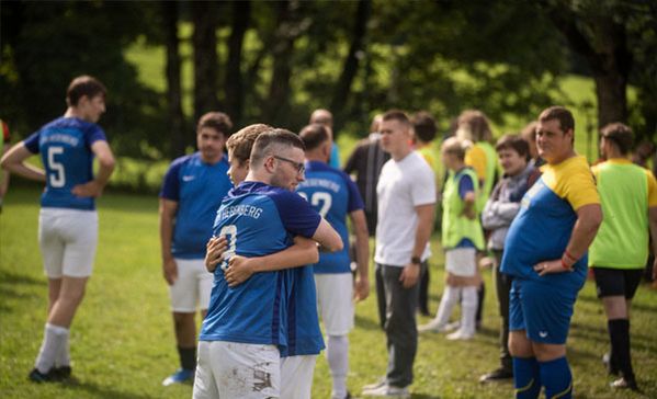 Zwei Personen umarmen sich auf dem Fußballfeld
