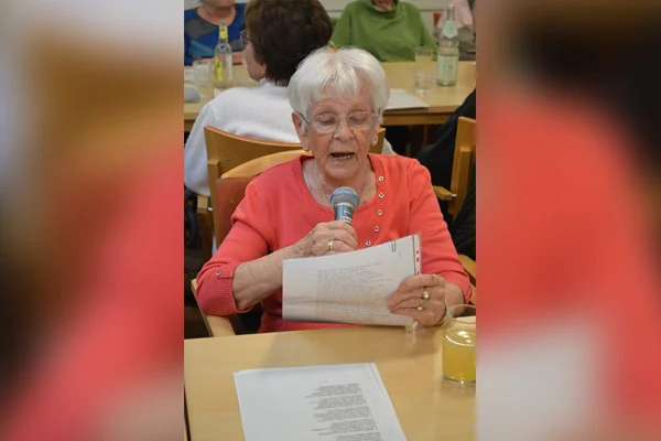 Mitsingen Eine Frau singt mit Mikrophon in der Hand.