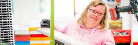 Das Bild zeigt eine junge Frau bei der Arbeit in einer Werkstatt