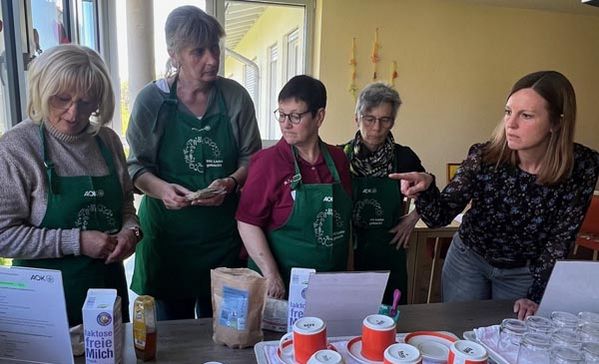 Mehrere Personen stehen an einem Tisch und besprechen etwas.
