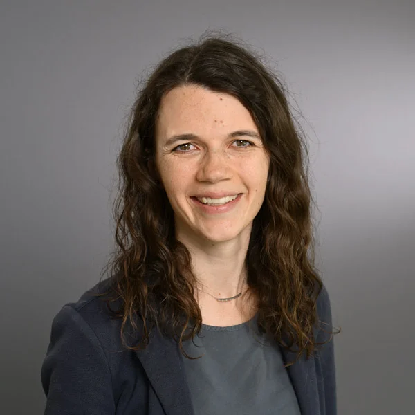 Eine Frau lächelt in die Kamera für ein Portraitfoto.