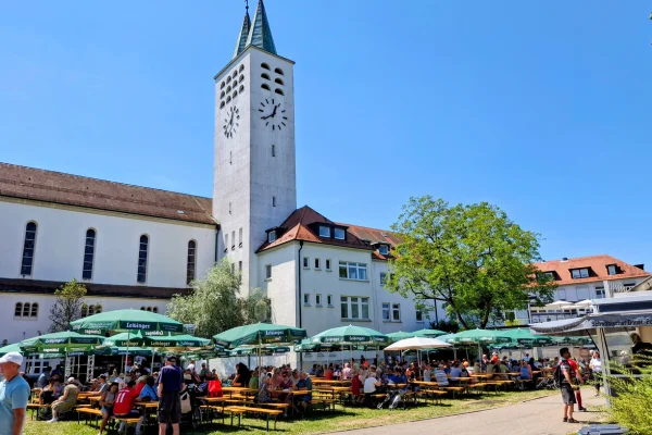 Ein Fest mit vielen Menschen, draußen vor einer Kirche.