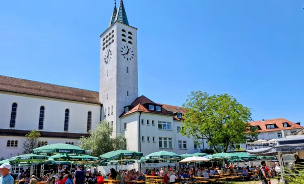Ein Fest mit vielen Menschen, draußen vor einer Kirche.