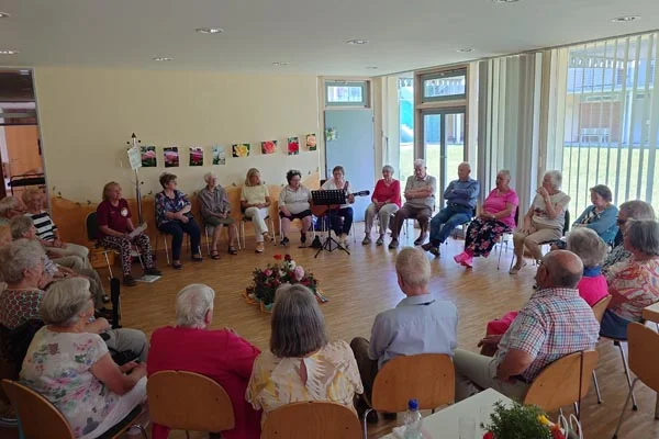 Jubiläum Die Gruppe im Kreis sitzend.
