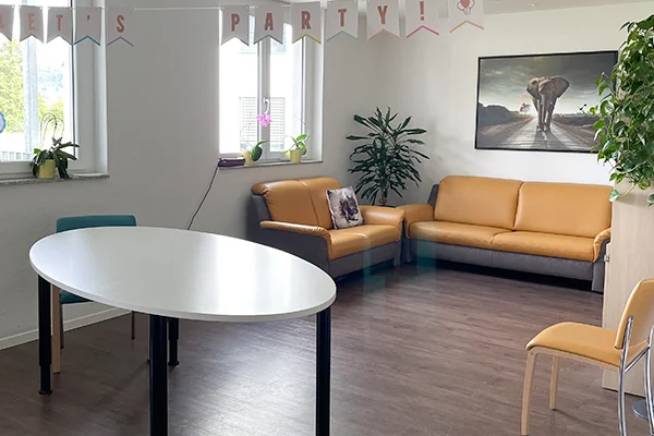 Gemeindeintegriertes Wohnen und Fördern Singen Das Bild zeig einen Wartebereich mit Sofa, Stühlen und Tisch