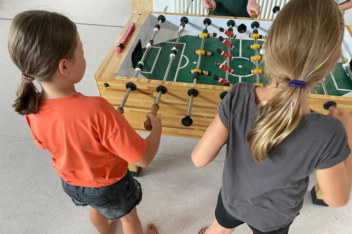 Ferienbetreuung Olympia Zwei kleine Mädchen spielen Tischkicker.