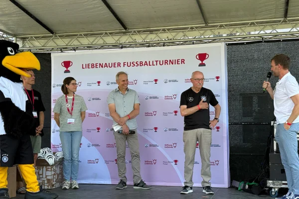 Pokal Mehrere Personen stehen auf einer Bühne und werden interviewt.