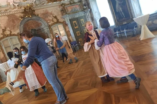 Das Bild zeigt Kinder in antiken Kostümen beim Tanzen
