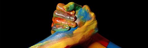 das bild zeigt zwei in farbe getauchte hände fest verschlungen