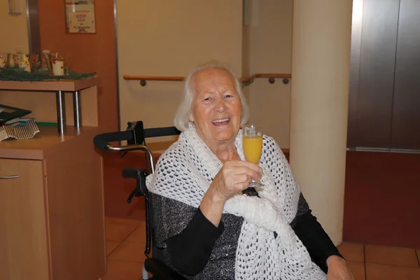 Spende des Fördervereins Das Foto zeigt die Bewohnerin Margarete Fischer mit einem Sektglas.