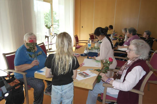 Kooperation Ein Kind übergibt mehreren Personen Rosen.