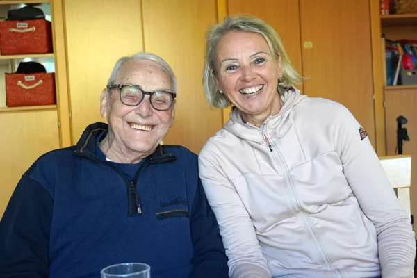 Bewohner Alfred Frick und die Teamleitung Marion Locher lächeln in die Kamera.