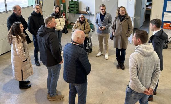 Mehrere Menschen stehen in einem Kreis und unterhalten sich