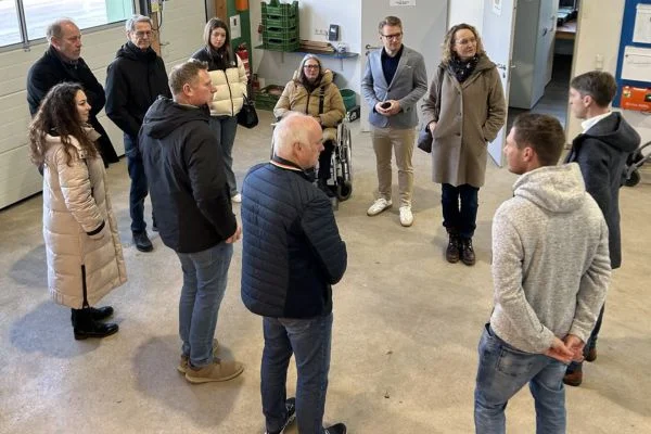 Mehrere Menschen stehen in einem Kreis und unterhalten sich