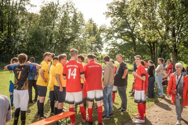 das bild zeigt eine gruppe fußballer, die sich in der runde besprechen.