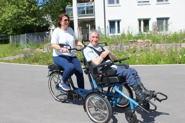 Rollstuhlfahrrad Das Foto zeigt Anja Rundel, Einrichtungsleitung Haus St. Raphael, und Karl Schlenska auf dem Rollstuhlfahrrad.