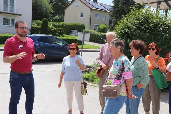 Pflegecampus Ein Mann erklärt einer Personengruppe etwas.