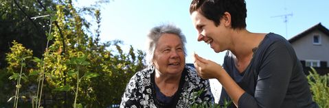 Das Bild zeigt zwei Frauen in einem Garten