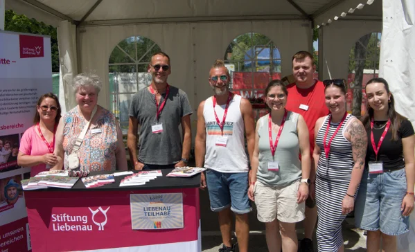 Mehrere Personen stehen hinter einem Stand der Stiftung Liebenau.