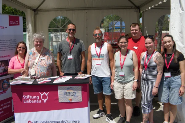 Mehrere Personen stehen hinter einem Stand der Stiftung Liebenau.