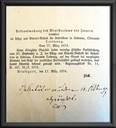 1873, Die rechtliche Gründung. 1873 verfasst die „Pfleg- und Bewahr-Anstalt für Unheilbare in Liebenau“ ihre Statuten. Die Eigenständigkeit Liebenaus wird nochmals betont: „Der Charakter der Anstalt soll der einer Privatanstalt sein, hervorgegangen aus christlicher Liebe, bestehend durch die freithätige christliche Liebe; ruhend auf katholisch kirchlicher Grundlage.“ Die Pflegeanstalt bekommt vom württembergischen Innenministerium das Recht der juristischen Persönlichkeit verliehen. Adolf Aich hofft, dadurch das Ansehen der Einrichtung zu steigern und noch mehr Spenden zu erhalten. Das Bild zeigt die Bekanntmachung des Ministeriums des Inneren von 1874.