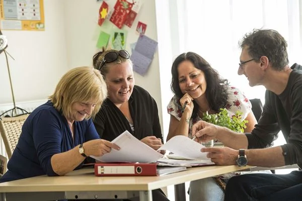 Das Bild zeigt eine Gruppe von Personen, die zusammen arbeiten.