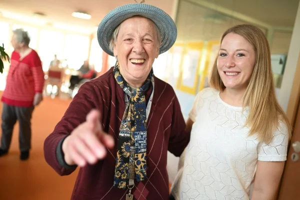 Das Bild zeigt eine junge und eine ältere Dame auf einem Flur