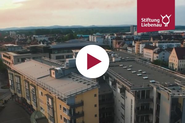 Eine Luftaufnahme vom Haus und ein Playbutton in der Mitte des Bilds.