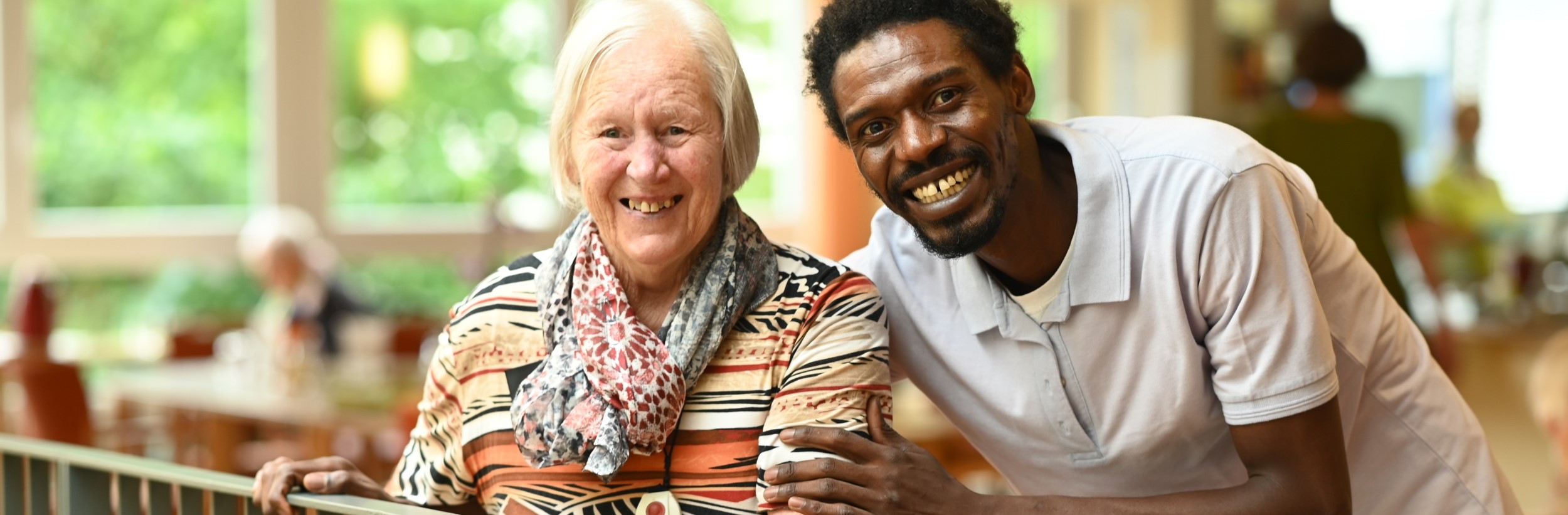 Das Bild zeigt eine alte Dame und erinen Pfleger im Haus der Pflege St. Barbara