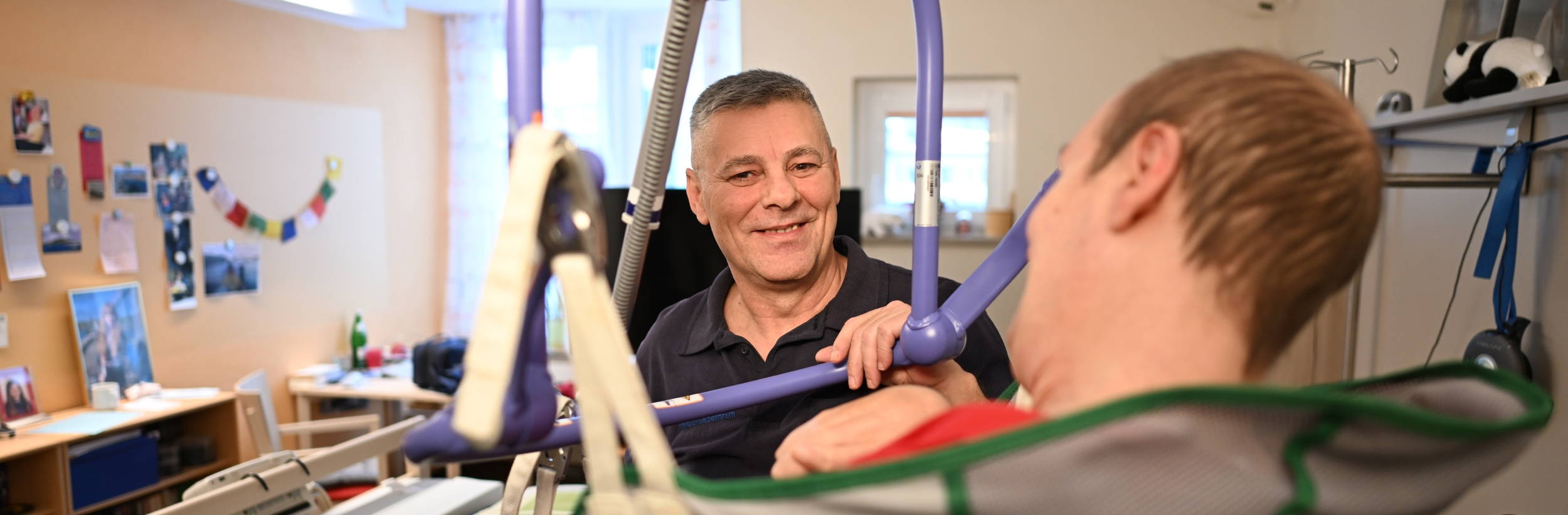 Das Bild zeigt einen Pfleger mit einem liegenden Patienten