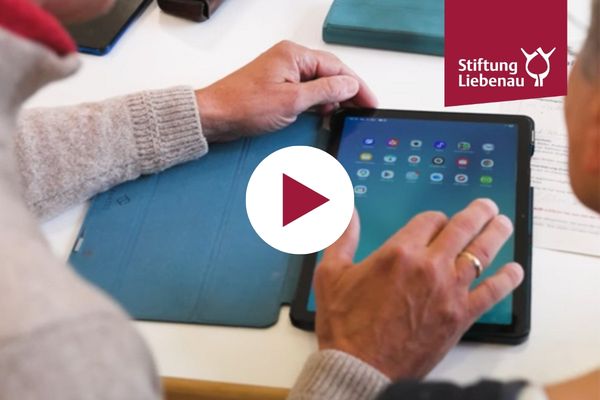 Eine Hand tippt auf einem Tablet.