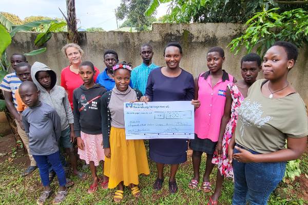 Zusammen mit Kindern und Jugendlichen nahm Pauline Monthe Mutua (4.v.r.), Direktorin der Sopadad Initiative Uganda, den Scheck über 700 Euro erfreut und dankbar an. Herta Maria Deiber hat ihn persönlich überreicht.