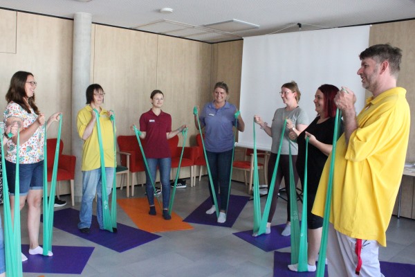 Kräftigungsübungen mit TheraBand: In einer heiteren Atmosphäre erhalten Mitarbeitende der Stiftung Liebenau im Haus der Pflege St. Raphael in Oberteuringen praxistaugliche Tipps für ihre Gesundheit. 