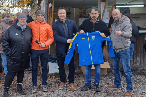 Das Foto zeigt die Übergabe einer Trainingsjacke.