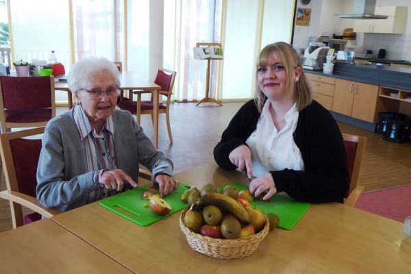 Gemeinsam macht das Kochen Spaß: Hauswirtschaftsleiterin Vanessa Ackrath (re.) beim Obst schnippeln mit Bewohnerin Christa Ahmann.