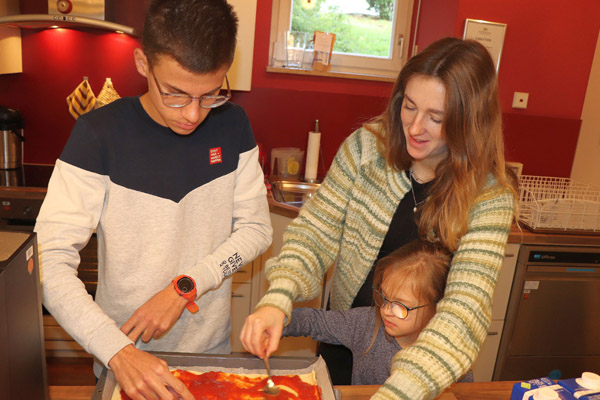 Gemeinsam belegen Konstantin, Irina Winder und die kleine Lajra die Pizza.