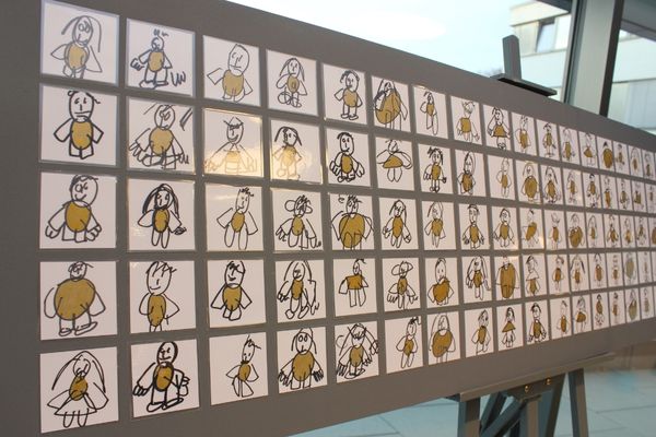 Strichmännchen Auf dem Bild ist ein ausgestelltes Gemälde zu sehen. Auf diesem Gemälde sind ganz viele verschiedene Strichmännchen zu sehen.