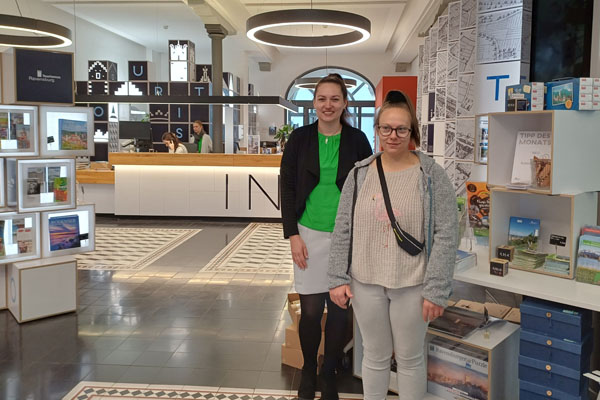 Nähwerk Zwei Personen stehen in einem Verkaufsladen und schauen in die Kamera.