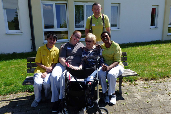 Das Foto zeigt einige Mitarbeiterinnen und Mitarbeiter und eine Bewohnerin.