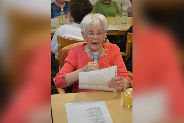 Eine Frau singt mit Mikrophon in der Hand.