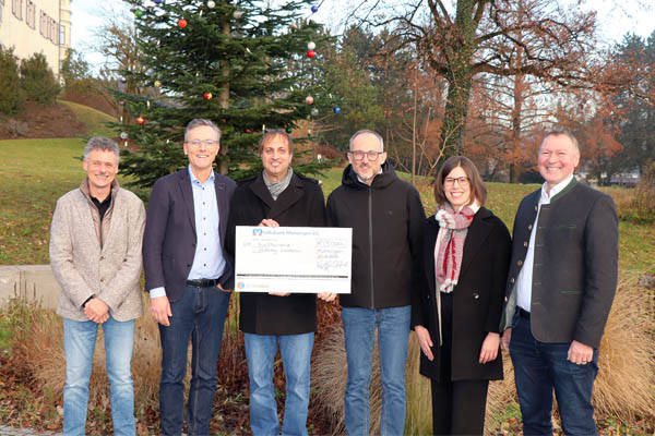 Spende Ein Gruppenbild mit 6 Personen und einem großen Scheck.