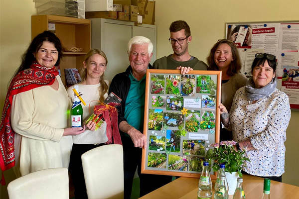 Presentübergabe Magnus Rau Das Foto zeigt Magnus Rauh mit dem Geschenk und weitere Personen.