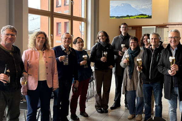 Eine Gruppenbild mit 10 Personen mit Gläsern in der Hand.