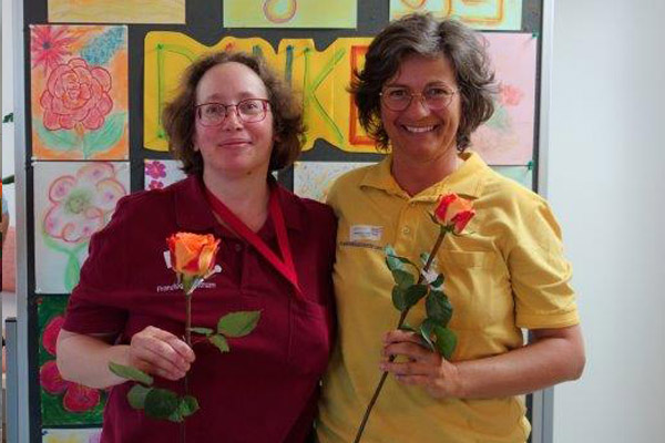Das Foto zeigt zwei Kolleginnen mit Rosen.
