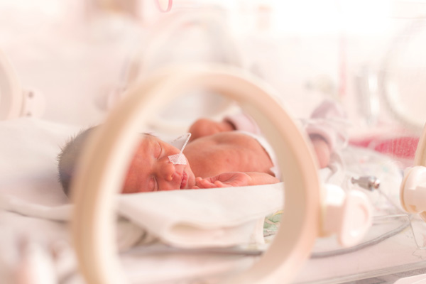 Ein Frühchen liegt in einem Bett.