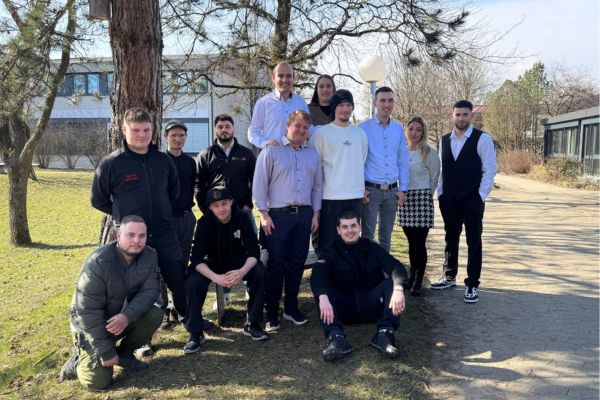 Eine Personengruppe lächelt in die Kamera