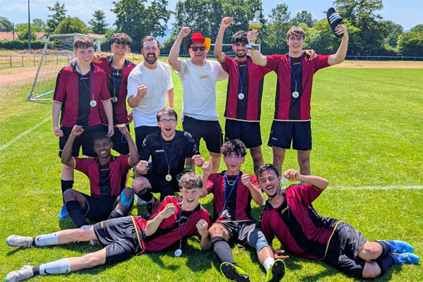 Fußballmeisterschaft Eine Fußballmannschaft beim Gruppenfoto jubelt.