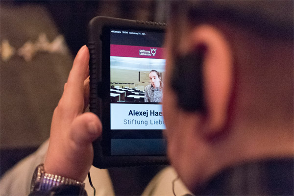 Wahlveranstaltung Eine Person schaut auf ein Tablet.
