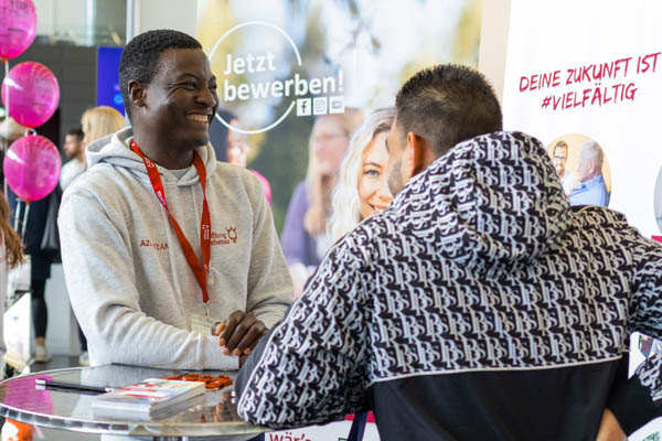 Zwei Männer unterhalten sich an einem Stehtisch auf einer Messe